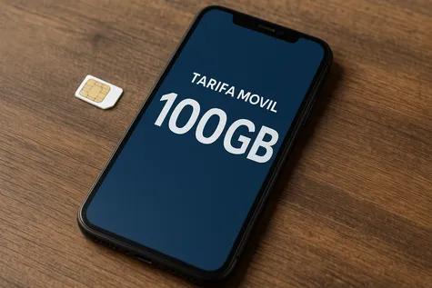 Smartphone sobre mesa de madera con pantalla que muestra “Tarifa móvil 100GB” junto a una tarjeta SIM.
